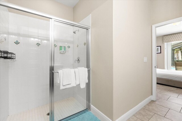 5353 Oakbourne Ave, Davenport, FL 33837 - ensuite bathroom with a stall shower, tile patterned floors, and baseboards