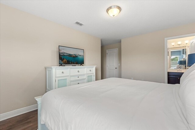 5353 Oakbourne Ave, Davenport, FL 33837 - bedroom featuring dark wood finished floors, baseboards, and connected bathroom