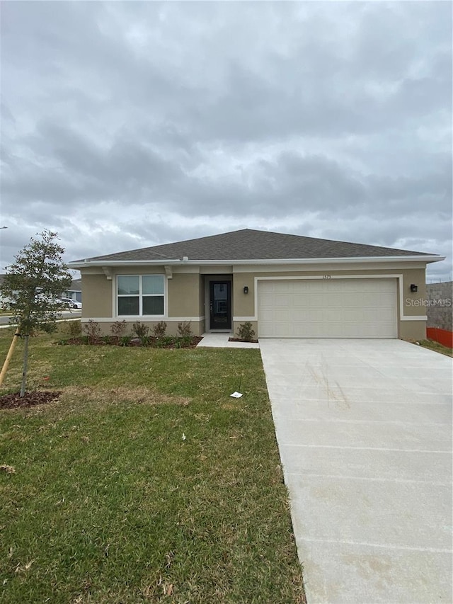 ranch-style home featuring stucco siding, concrete driveway, an attached garage, and a front lawn