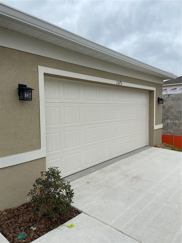 garage featuring concrete driveway