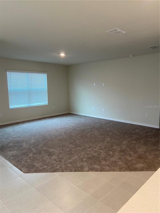 carpeted spare room featuring baseboards, recessed lighting, and tile patterned flooring