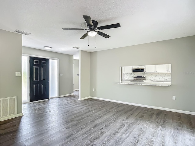 43 Lake Court Loop, Ocala, FL 34472 - unfurnished living room featuring dark wood-style flooring, a ceiling fan, baseboards, and a textured ceiling