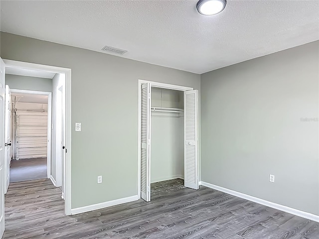 43 Lake Court Loop, Ocala, FL 34472 - unfurnished bedroom featuring wood finished floors, baseboards, a closet, and a textured ceiling