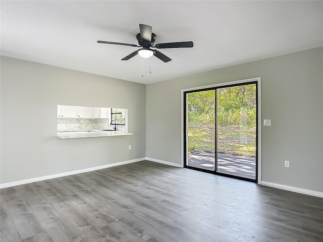 43 Lake Court Loop, Ocala, FL 34472 - empty room featuring dark wood-style flooring, baseboards, ceiling fan, a textured ceiling, and a sink