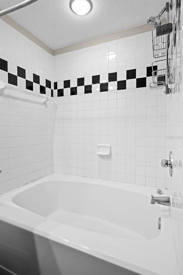 2411 W Horatio St Unit 537, Tampa, FL 33609 - bathroom featuring a textured ceiling and washtub / shower combination