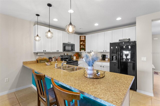 281 Primrose Dr, Davenport, FL 33837 - kitchen featuring black appliances, a peninsula, light tile patterned flooring, white cabinetry, and a kitchen bar