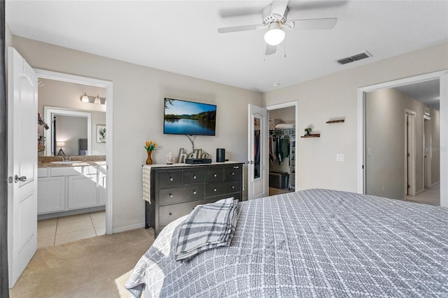 281 Primrose Dr, Davenport, FL 33837 - carpeted bedroom featuring a walk in closet, tile patterned flooring, a closet, ensuite bath, and ceiling fan