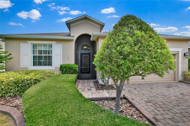 3677 Serena Ln, Clermont, FL 34711 - view of front of home with stucco siding, a front lawn, driveway, and an attached garage