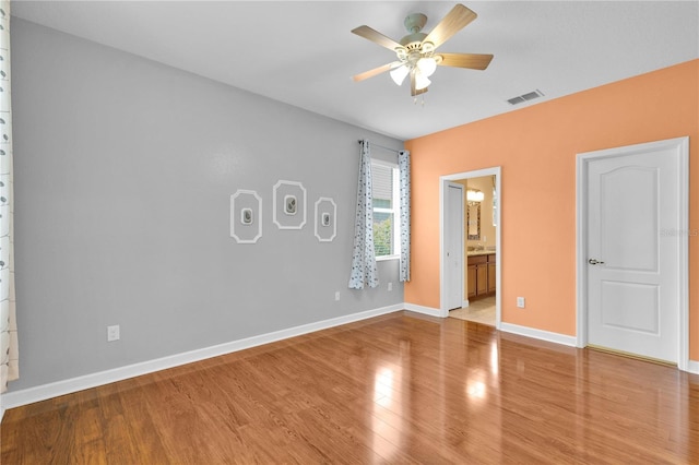 3677 Serena Ln, Clermont, FL 34711 - unfurnished bedroom featuring light wood-type flooring, baseboards, ensuite bath, and ceiling fan