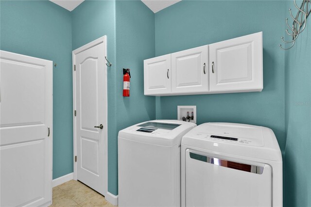 3677 Serena Ln, Clermont, FL 34711 - washroom featuring washing machine and dryer, cabinet space, light tile patterned floors, and baseboards