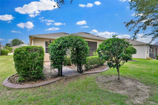 3677 Serena Ln, Clermont, FL 34711 - view of property exterior with stucco siding, a lawn, and central AC