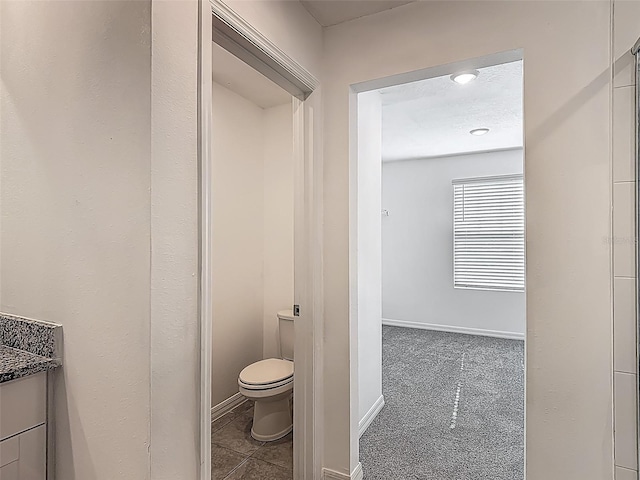 bathroom with toilet, vanity, and baseboards