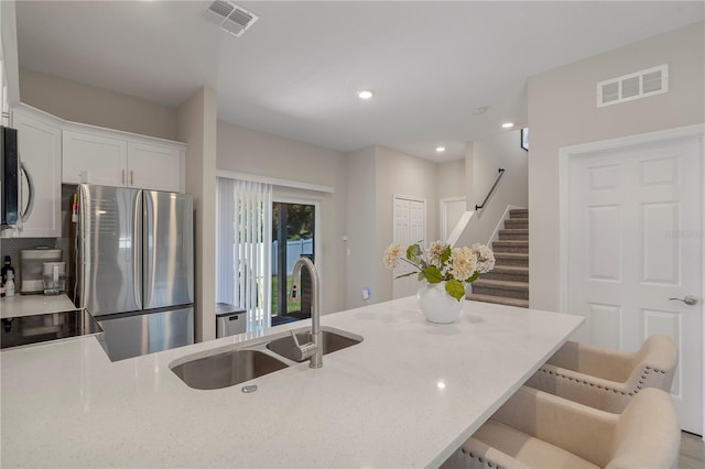 146 E 15th St, Apopka, FL 32703 - kitchen featuring stainless steel appliances, a sink, light stone counters, white cabinets, and recessed lighting