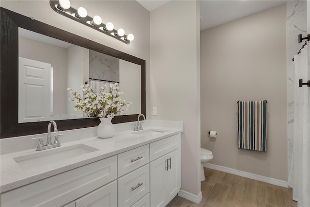 146 E 15th St, Apopka, FL 32703 - bathroom featuring toilet, double vanity, and baseboards
