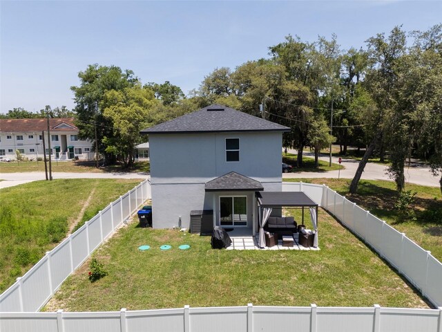 146 E 15th St, Apopka, FL 32703 - back of property with a patio area, a shingled roof, outdoor lounge area, and stucco siding