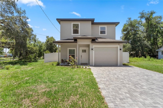 146 E 15th St, Apopka, FL 32703 - view of front of house featuring stucco siding, decorative driveway, a front yard, and an attached garage