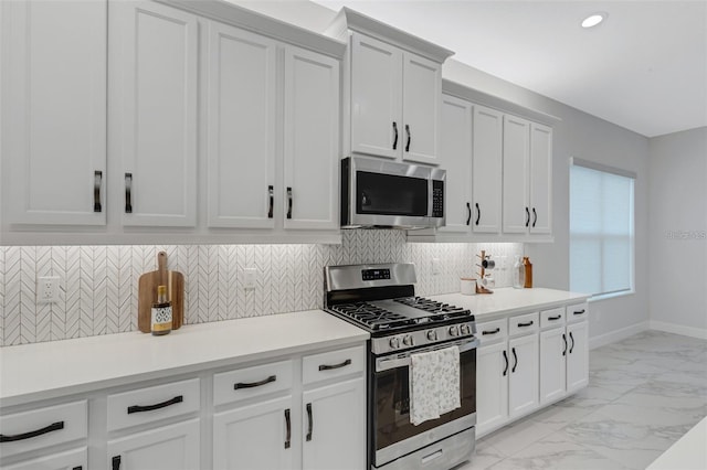 kitchen featuring appliances with stainless steel finishes, light marble finish floors, tasteful backsplash, light countertops, and recessed lighting
