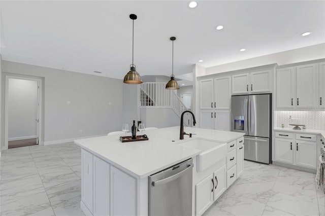 kitchen featuring stainless steel appliances, light marble finish floors, a sink, light countertops, and recessed lighting