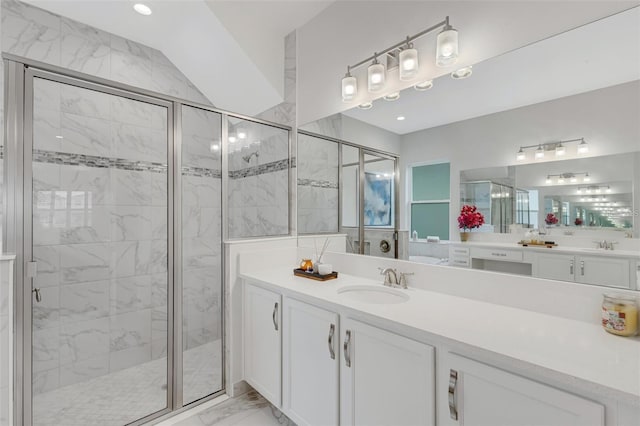 full bath with marble look tile flooring, a stall shower, and vanity
