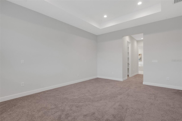 unfurnished room featuring recessed lighting, carpet flooring, baseboards, and a tray ceiling