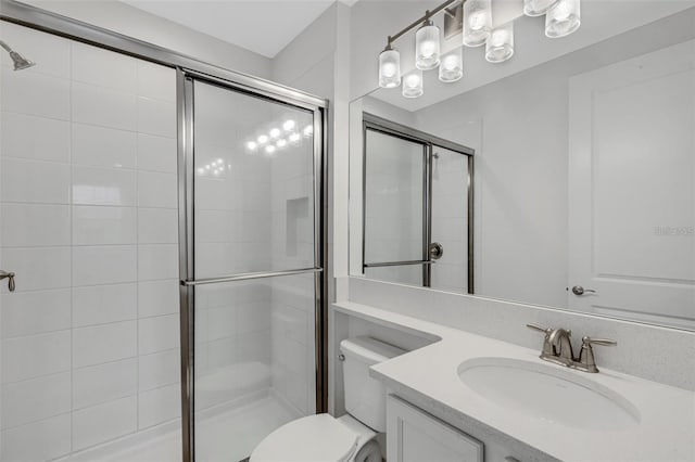 full bath with a stall shower, toilet, and vanity