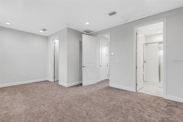 unfurnished bedroom with attic access, light carpet, baseboards, recessed lighting, and ensuite bath