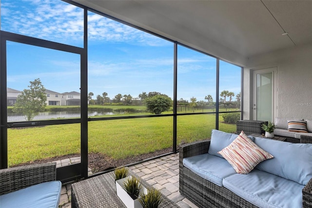 sunroom / solarium with a water view and an outdoor living space