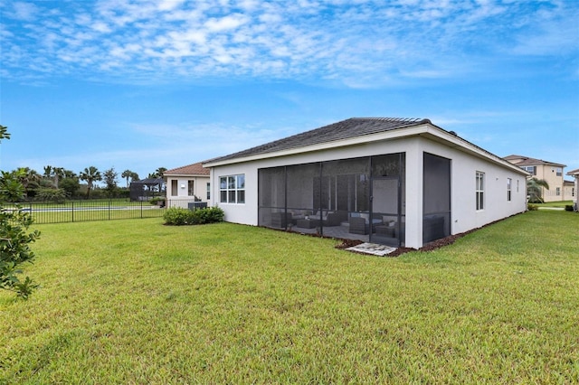 rear view of property with stucco siding and a sunroom
