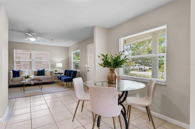 614 Plum Ln, Altamonte Springs, FL 32701 - dining room featuring baseboards, light tile patterned floors, a ceiling fan, and a textured ceiling