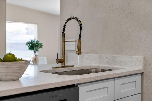 614 Plum Ln, Altamonte Springs, FL 32701 - kitchen view of a sink, white cabinetry, dishwashing machine, and light stone counters