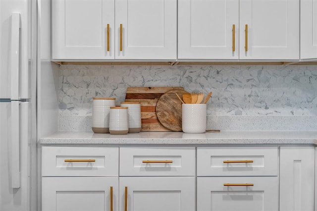 614 Plum Ln, Altamonte Springs, FL 32701 - kitchen view of freestanding refrigerator, tasteful backsplash, white cabinetry, and light stone countertops