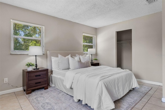 614 Plum Ln, Altamonte Springs, FL 32701 - bedroom featuring light tile patterned floors, a closet, baseboards, and a textured ceiling