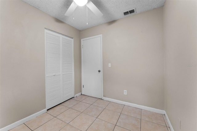 614 Plum Ln, Altamonte Springs, FL 32701 - unfurnished bedroom featuring a textured ceiling, a closet, baseboards, light tile patterned floors, and ceiling fan