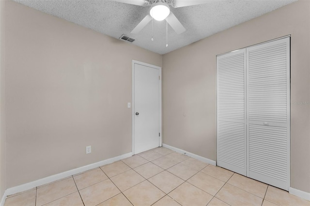 614 Plum Ln, Altamonte Springs, FL 32701 - unfurnished bedroom featuring a closet, baseboards, light tile patterned flooring, a textured ceiling, and ceiling fan