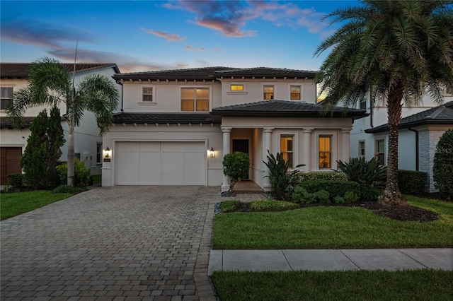 10529 Royal Cypress Way, Orlando, FL 32836 - view of front facade with decorative driveway, a garage, a tiled roof, stucco siding, and a lawn