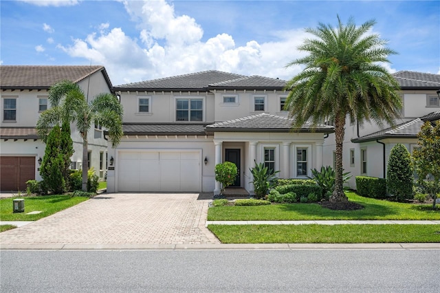 10529 Royal Cypress Way, Orlando, FL 32836 - view of front of home featuring decorative driveway, an attached garage, stucco siding, a tiled roof, and a front yard