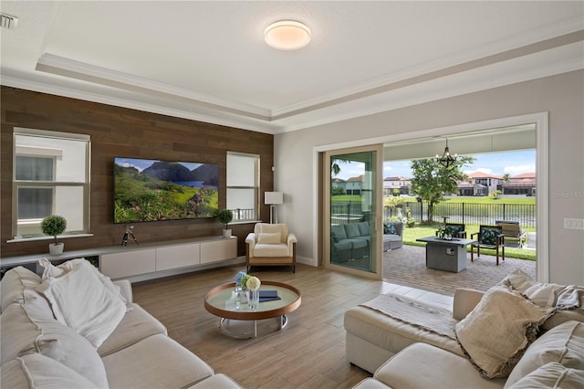10529 Royal Cypress Way, Orlando, FL 32836 - living area with a tray ceiling, a chandelier, crown molding, light wood-style floors, and wood walls