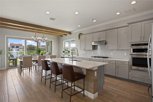 10529 Royal Cypress Way, Orlando, FL 32836 - kitchen featuring gray cabinetry, under cabinet range hood, double oven, wood finished floors, and recessed lighting