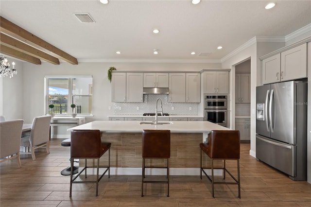 10529 Royal Cypress Way, Orlando, FL 32836 - kitchen featuring appliances with stainless steel finishes, light countertops, gray cabinetry, tasteful backsplash, and a kitchen island with sink