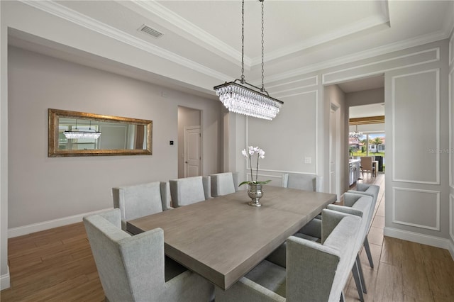 10529 Royal Cypress Way, Orlando, FL 32836 - dining room featuring wood finished floors, a tray ceiling, a chandelier, and ornamental molding