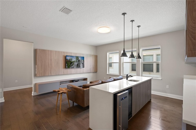 10529 Royal Cypress Way, Orlando, FL 32836 - kitchen with dark wood-type flooring, a textured ceiling, light countertops, modern cabinets, and a center island with sink