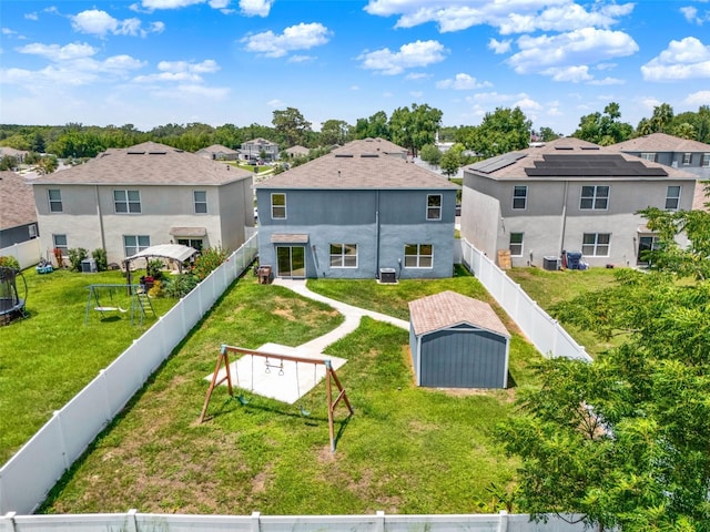 5967 Churchill Square Way, Groveland, FL 34736 - back of property with a residential view, central AC unit, and stucco siding