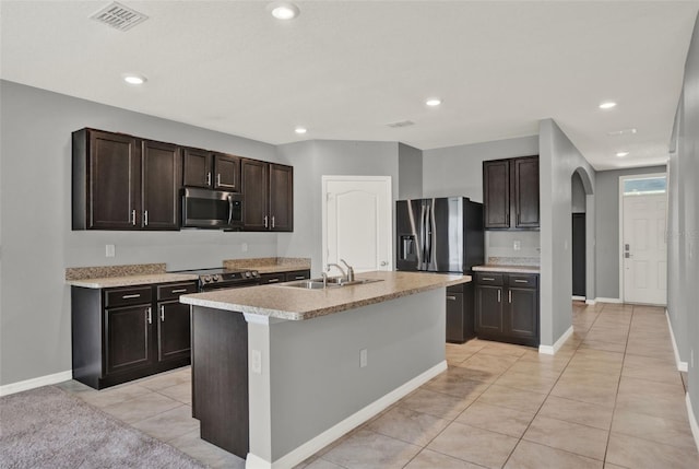 5967 Churchill Square Way, Groveland, FL 34736 - kitchen with appliances with stainless steel finishes, arched walkways, a sink, light countertops, and dark brown cabinetry
