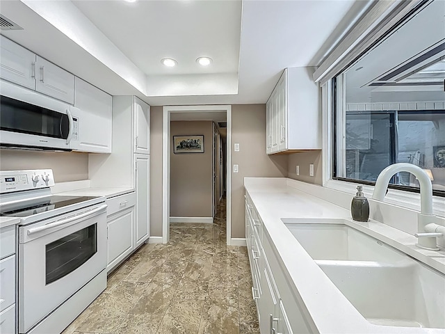 103 Red Cedar Dr, Longwood, FL 32779 - kitchen featuring white appliances, a sink, white cabinets, light countertops, and baseboards
