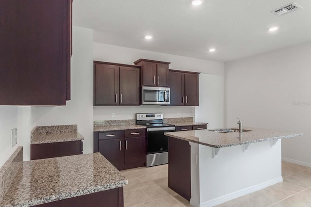 3975 Kennebunk Loop, Mount Dora, FL 32757 - kitchen with stainless steel appliances, a sink, light stone counters, recessed lighting, and a breakfast bar