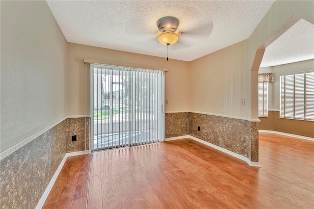 935 Northern Dancer Way Unit 107, Casselberry, FL 32707 - empty room featuring wood finished floors, a textured ceiling, wainscoting, ceiling fan, and baseboards