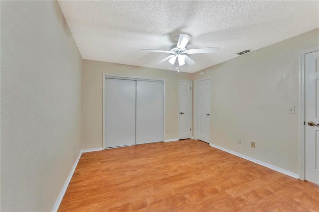 935 Northern Dancer Way Unit 107, Casselberry, FL 32707 - unfurnished bedroom featuring a textured ceiling, baseboards, light wood finished floors, ceiling fan, and a closet