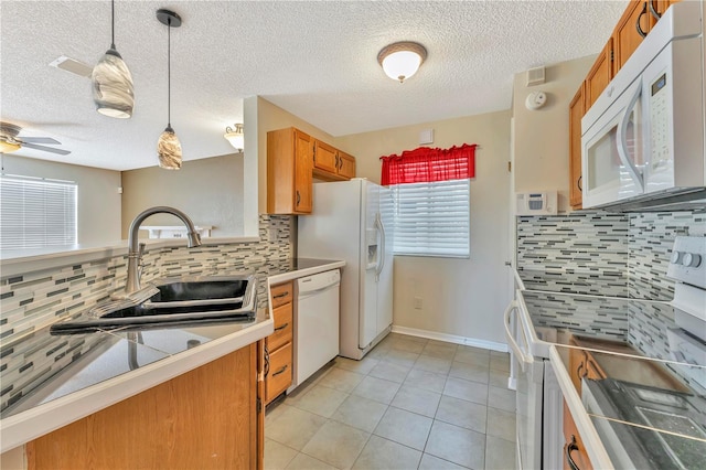 935 Northern Dancer Way Unit 107, Casselberry, FL 32707 - kitchen with white appliances, a sink, brown cabinetry, tasteful backsplash, and pendant lighting