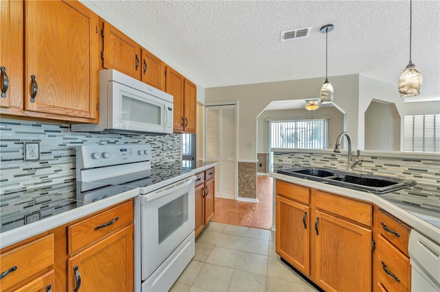 935 Northern Dancer Way Unit 107, Casselberry, FL 32707 - kitchen featuring white appliances, a sink, light tile patterned floors, hanging light fixtures, and tasteful backsplash