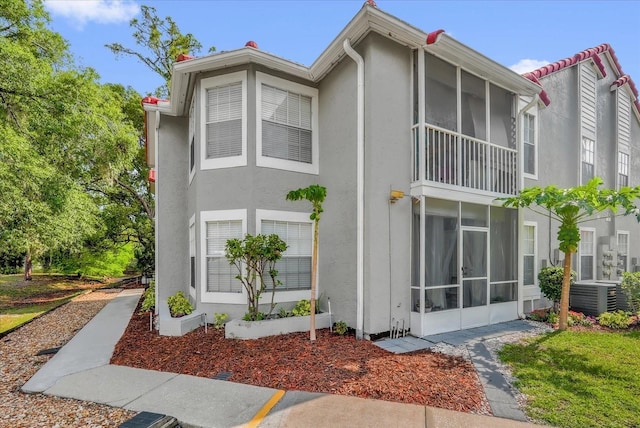 935 Northern Dancer Way Unit 107, Casselberry, FL 32707 - view of side of home with stucco siding, a sunroom, and cooling unit
